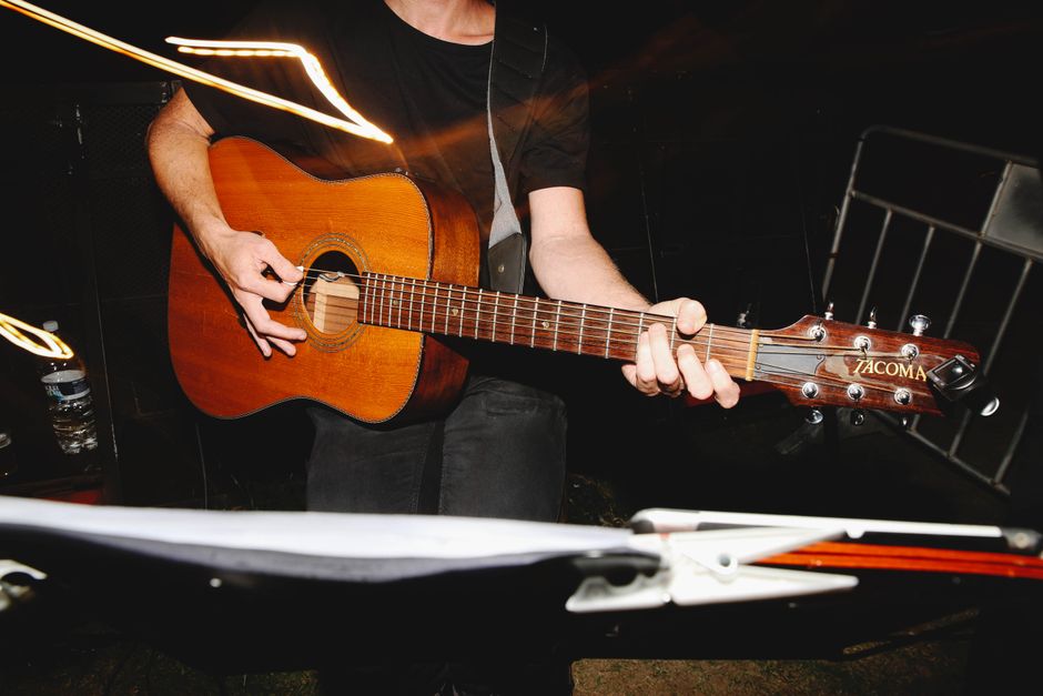 Guitarrista eléctrico en escenario con luces rojas durante concierto de thrash metal