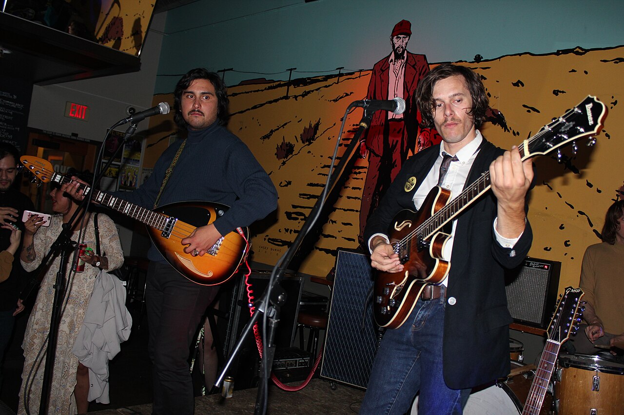 Bajista y guitarrista tocando en vivo durante un concierto de rock