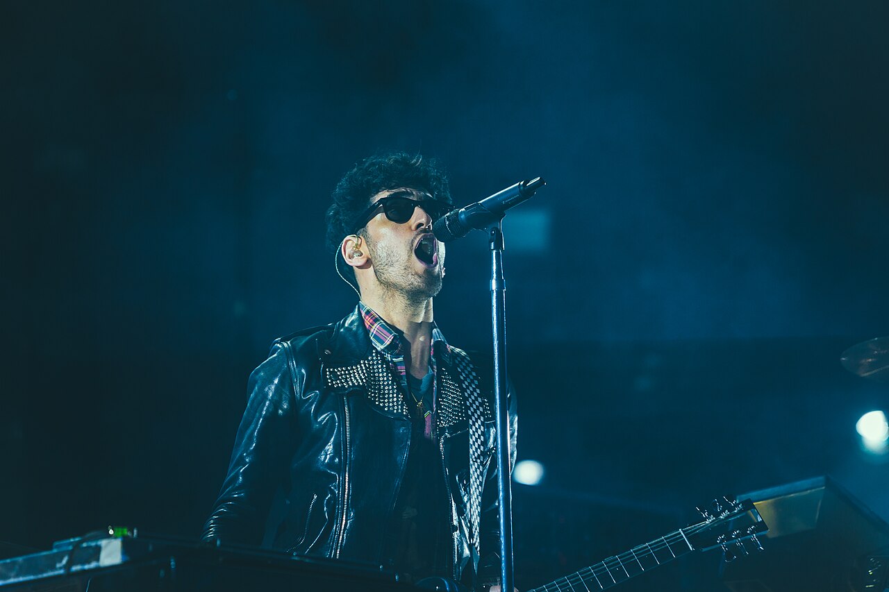 Cantante interpretando frente al micrófono durante un concierto en vivo