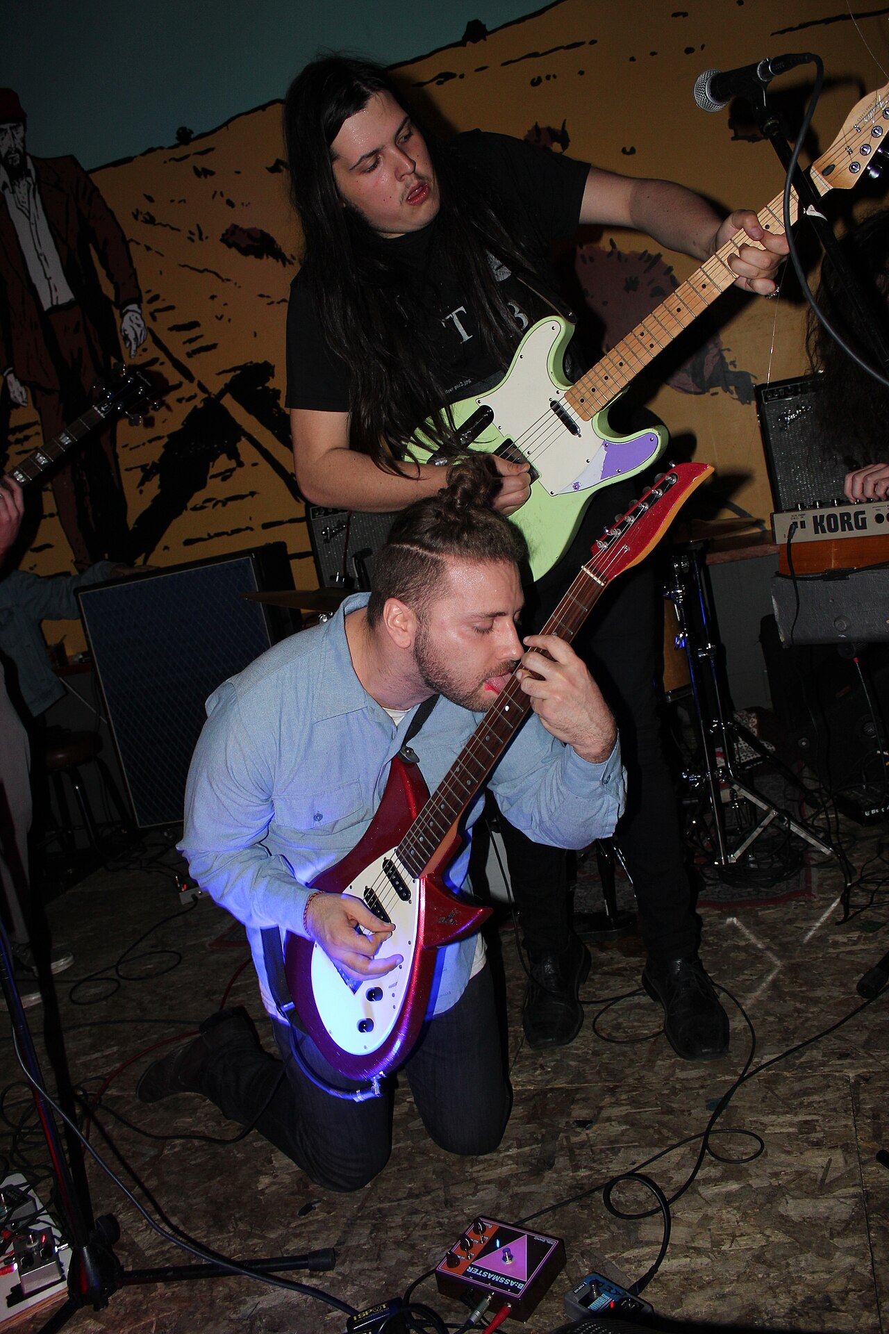 Dos guitarristas tocando en vivo sobre el escenario durante un concierto de rock
