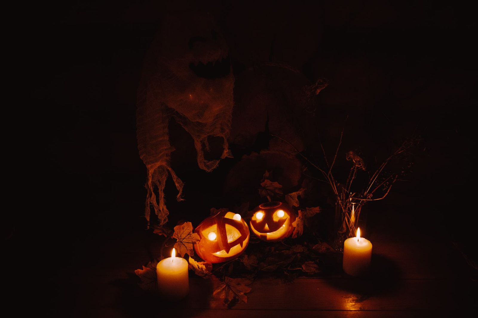 Decoración de Halloween con calabazas brillantes y velas en la oscuridad, ambiente de Ice Nine Kills y su EP navideño de terror
