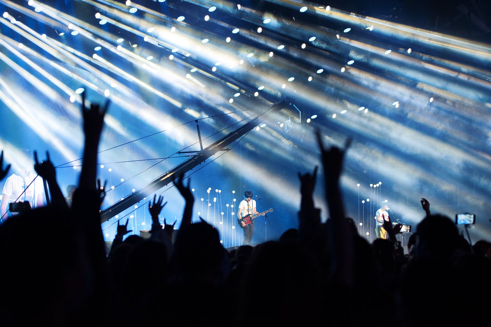 Público ovacionando un concierto de rock con luces dramáticas, ambiente del Hollywood Bowl