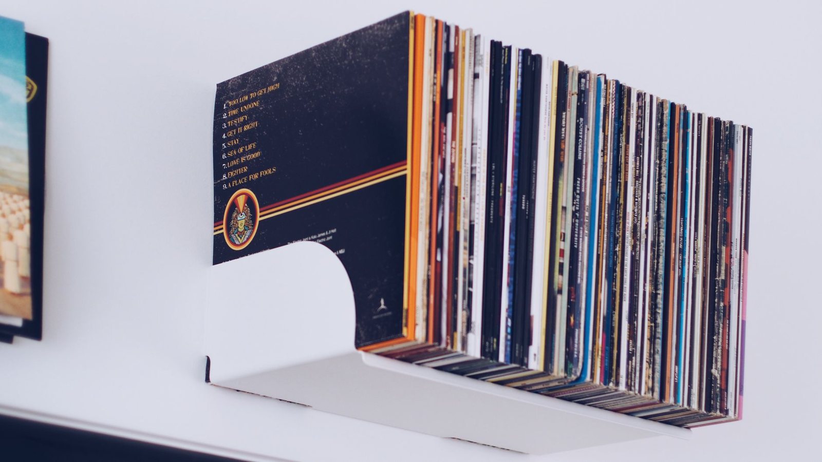 Colección de discos compactos y vinilos en un estante, edición aniversario de Razorblade Suitcase