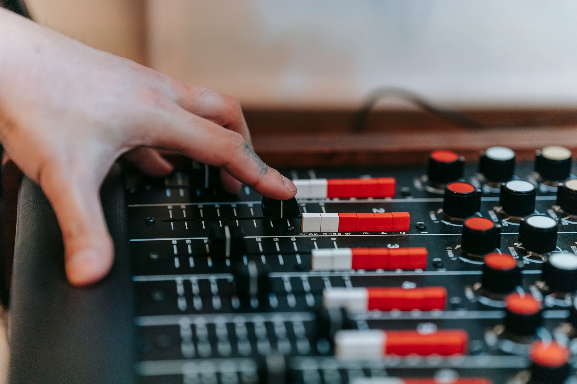 Mano ajustando los controles de una consola de estudio, imagen de referencia de la escritura del disco de Killswitch Engage