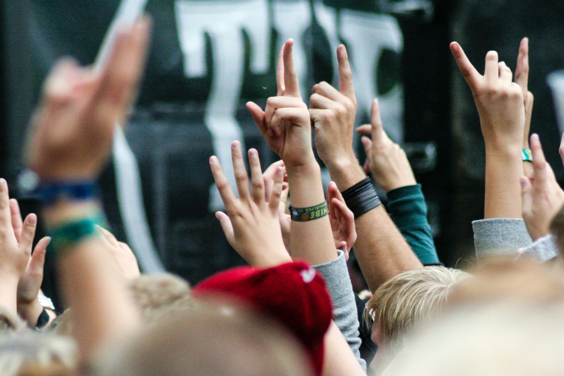 Personas levantan las manos durante un concierto en vivo, como en un festival de metal y hardcore