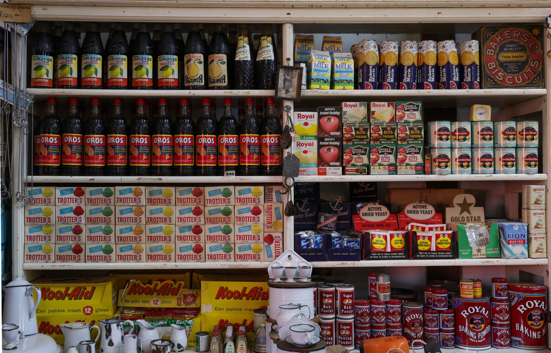 Estante de una tienda de abarrotes vintage con botellas y latas, imagen de referencia de la historia de Melvin Loman